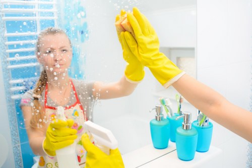 Professional cleaner washing external windows and frames in Bromley